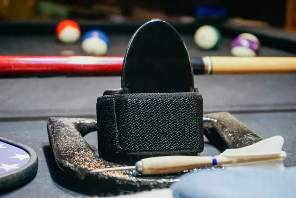 A black wallet sitting on top of a pool table.