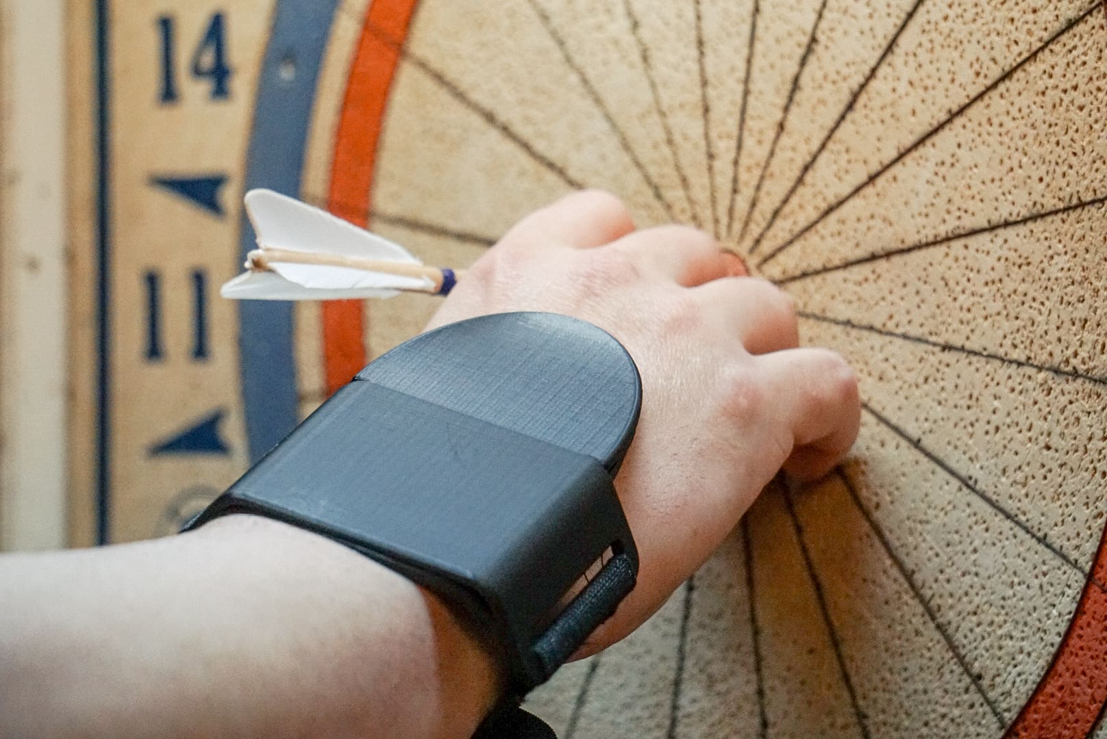 A person with a wrist band is holding on to the arrow.