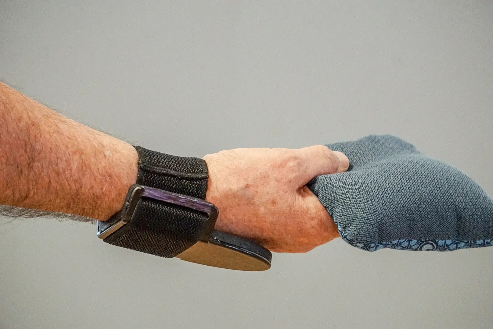 A person wearing gloves and holding onto another persons hand