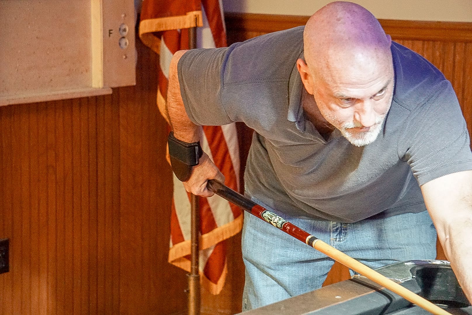 A man with a beard and purple hair holding a hammer.